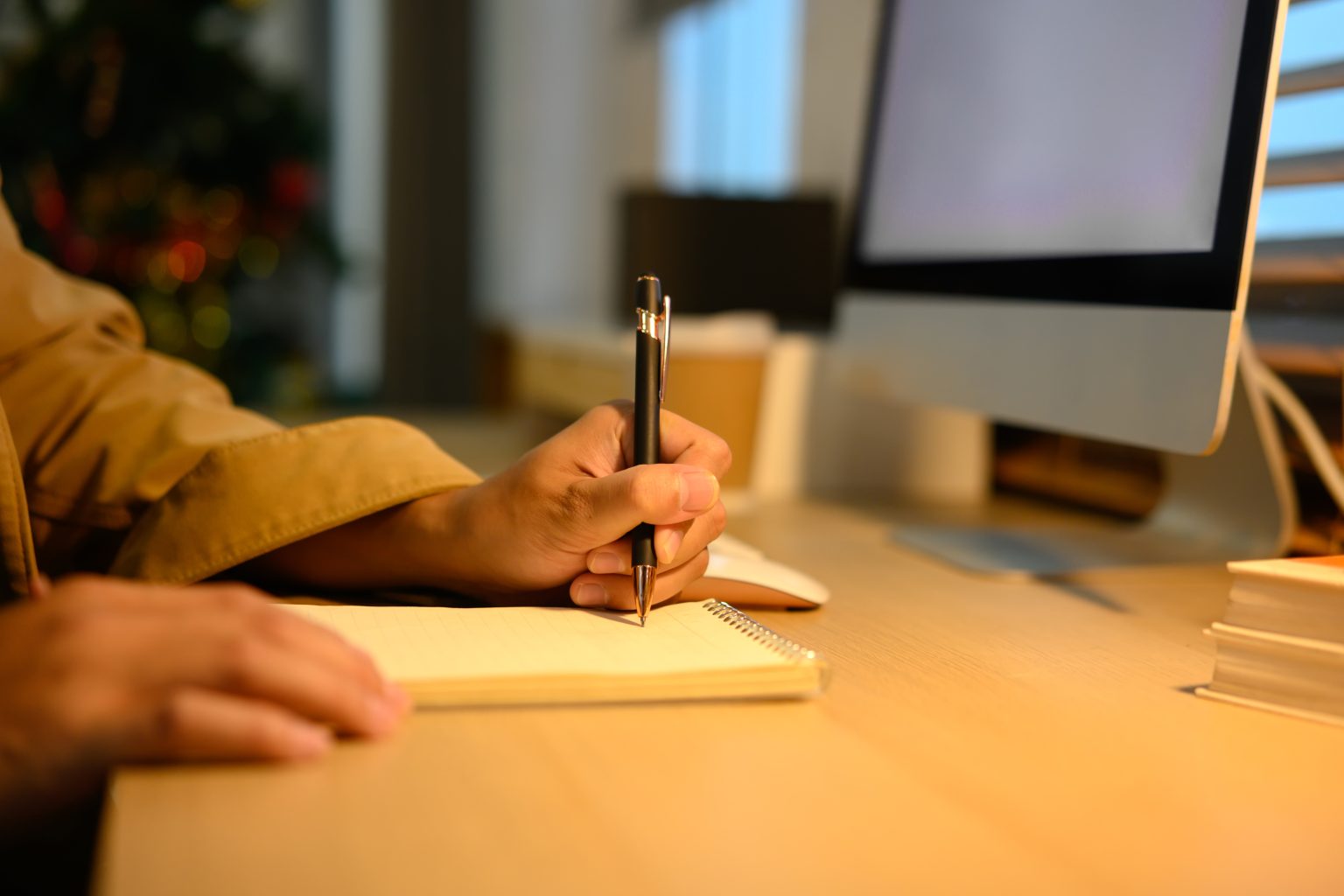 Filmmaker writing notes while working at a laptop