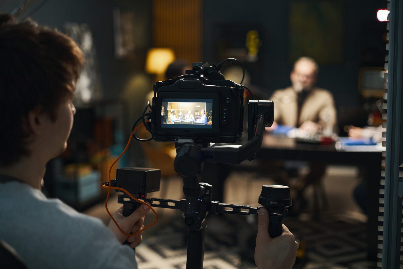Camera operator filming a recorded conversation in a studio