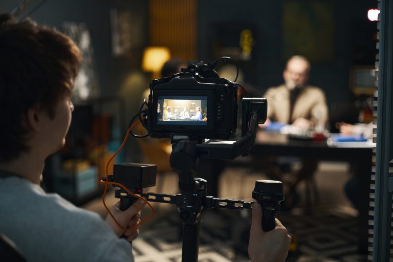 Camera operator framing a shot during a studio video recording